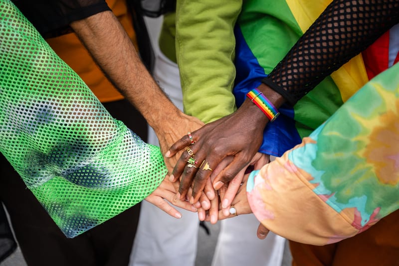 Groupe diversifié de personnes unissant leurs mains, symbolisant l'inclusion